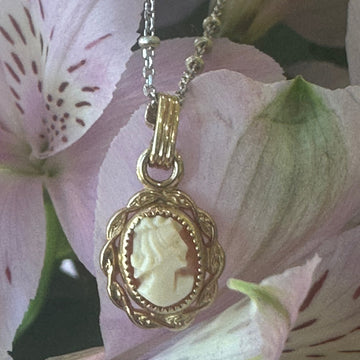 Gold necklace with a pendant on pink flowers