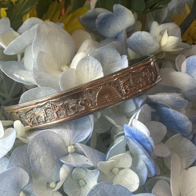 Decorative gold bracelet on a background of blue and white flowers