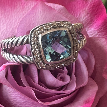 Silver ring with a gemstone on a pink rose