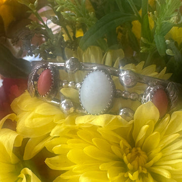 Silver pendant with red stones on a yellow flower background