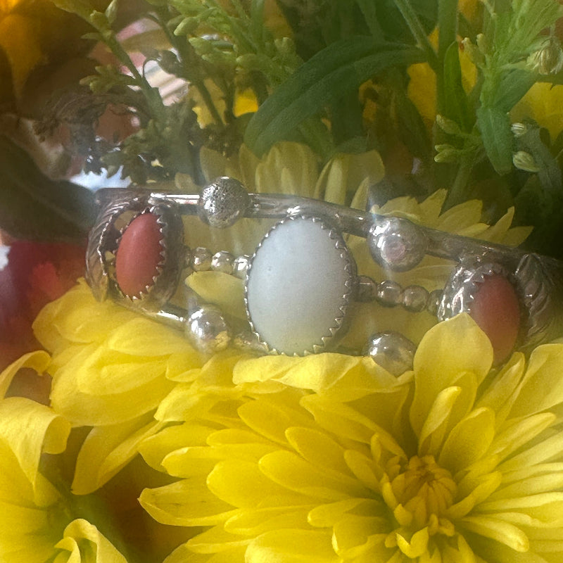 Silver pendant with red stones on a yellow flower background