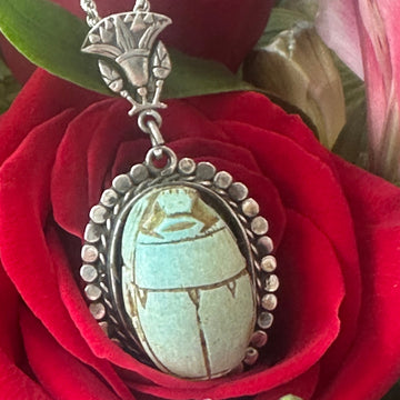 Silver pendant with turquoise stone on a red rose