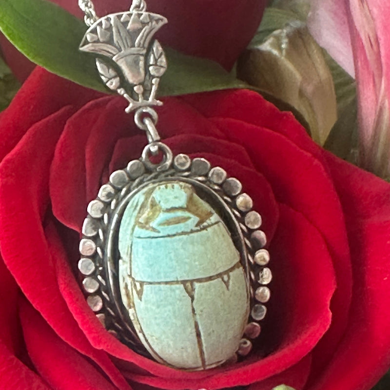 Silver pendant with turquoise stone on a red rose