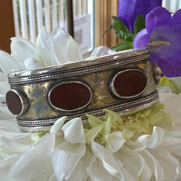 Decorative silver object with brown centers on a white flower