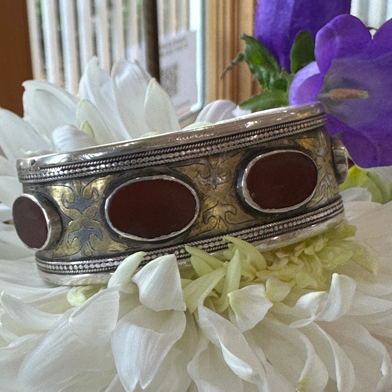 Decorative silver object with brown centers on a white flower